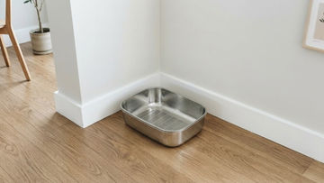 Minimalist home corner shot of Furrbby sifting stainless steel litter box, flat low-height stainless steel litter box blends with modern wooden floor decor